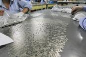 Workers preparing magnet parts