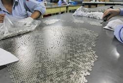 Workers preparing magnet parts