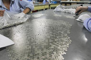 Workers preparing magnet parts