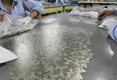Workers preparing magnet parts