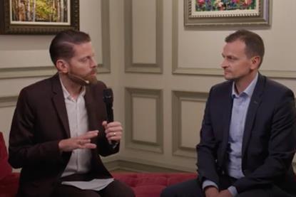 Gabriel Mair sits with Christopher Ludwig on a red sofa for an interview