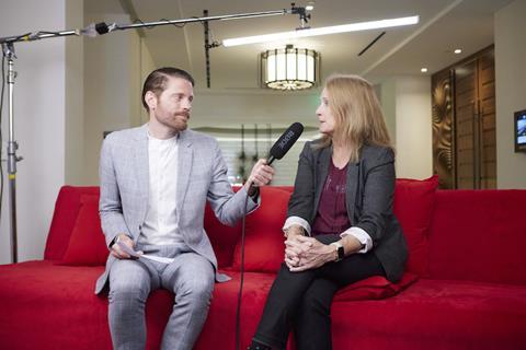 Rory Hepner sits on a red sofa alongside Christopher Ludwig at the Finished Vehicle Logistics conference