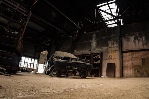 Rusting car in warehouse